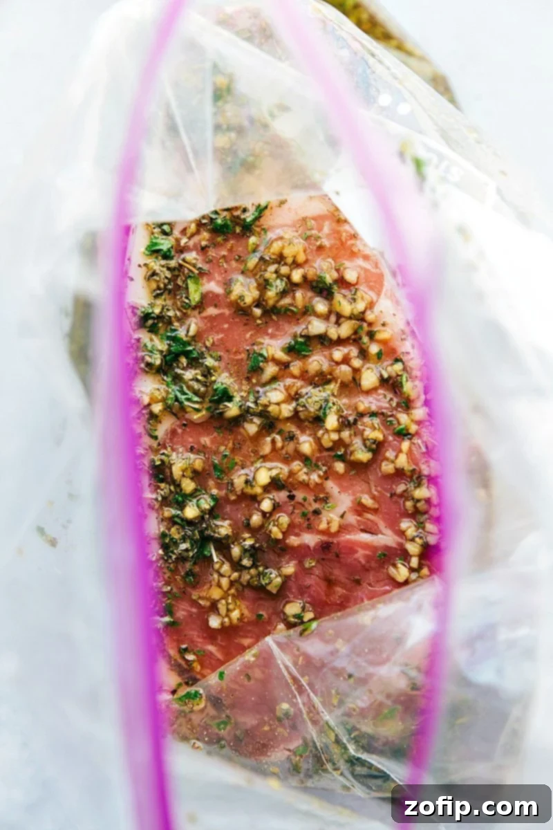 Steak marinade will tenderize your steak and make it super juicy and delicious! Overhead shot of New York Strip steaks soaking in a flavorful steak marinade in a dish