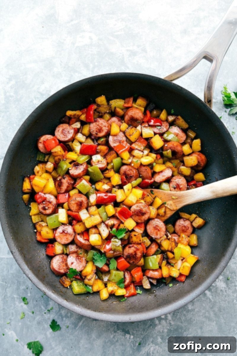 Sheet Pan Sausage and Roasted Vegetables 5 Close-up of a skillet filled with a colorful and hearty smoked sausage and vegetable hash.