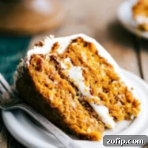 Slice of pumpkin carrot cake revealing its soft and moist interior, topped with a delicious icing.