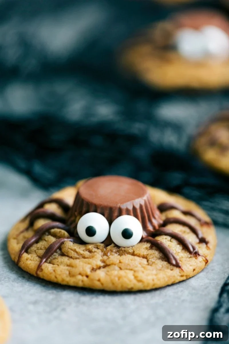 Delicious and spooky Peanut Butter Spider Cookies with Reese's Cups and chocolate legs, perfect for a Halloween party.