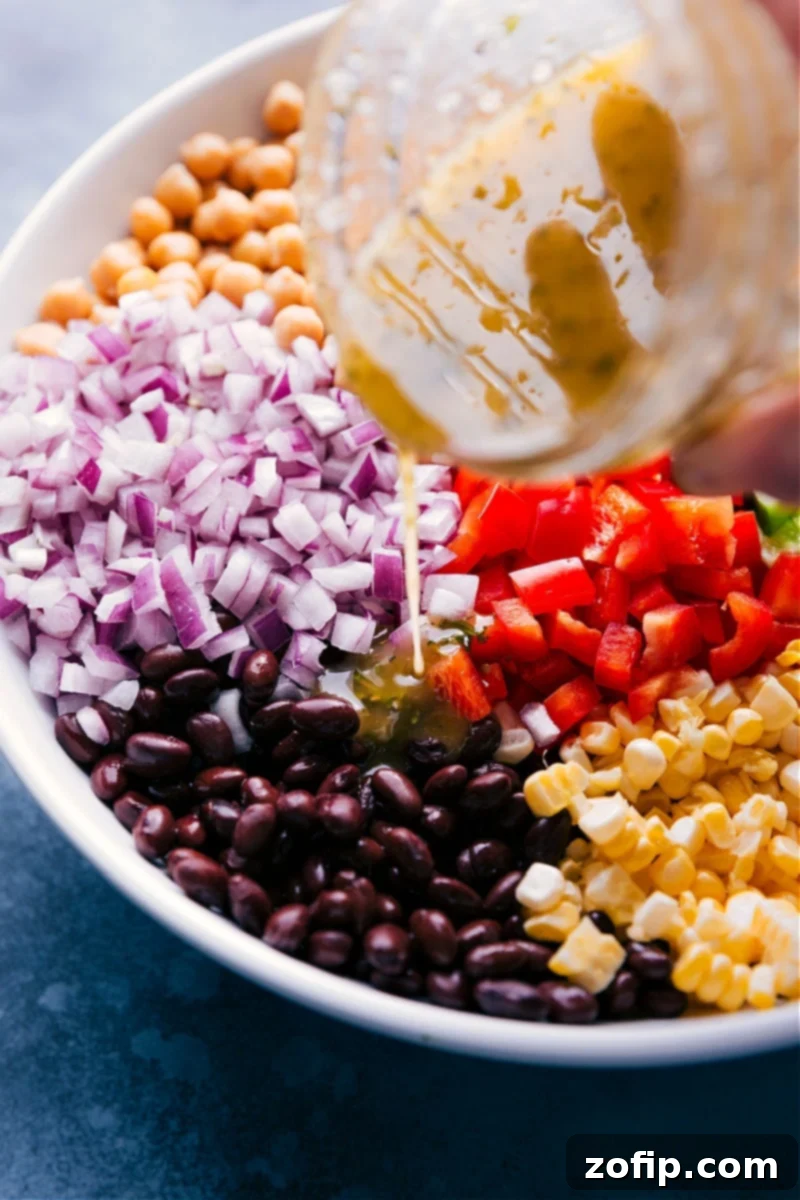 Image of the Italian-inspired dressing being poured over the Garbanzo Bean Salad, glistening with flavor.