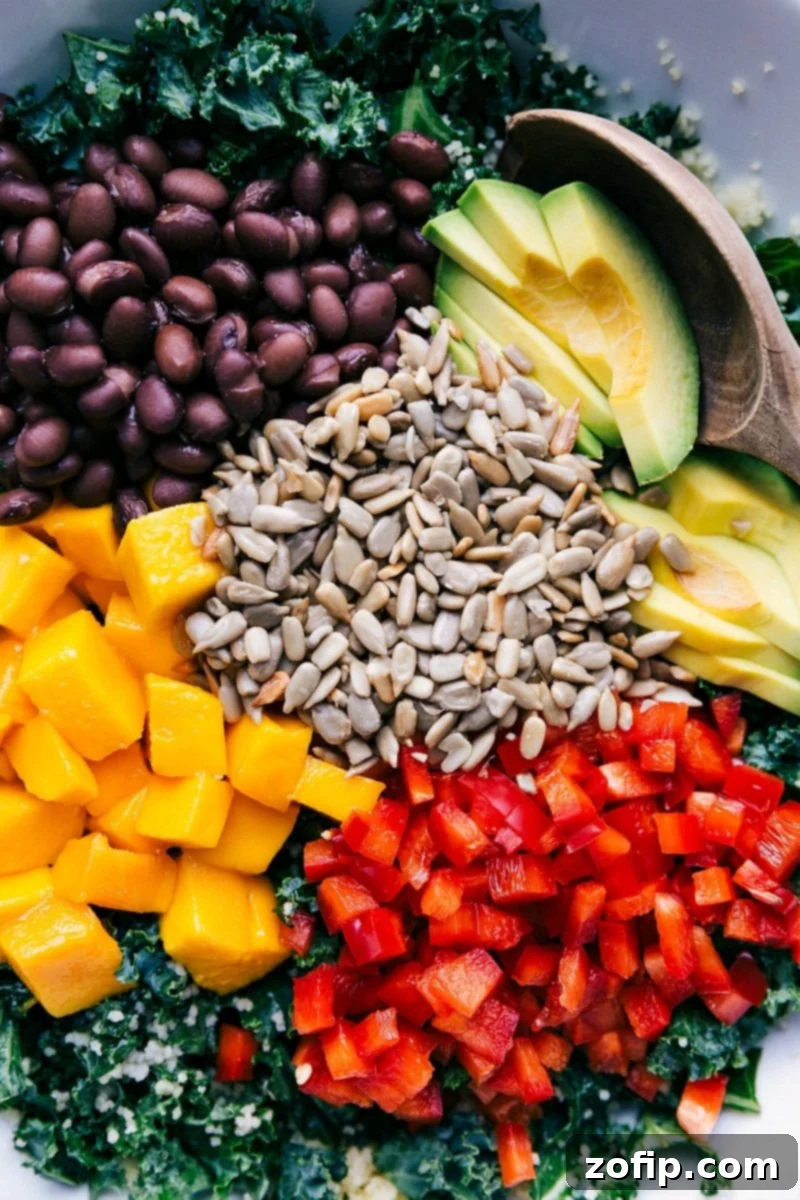 Organized View of Ingredients for Kale Couscous Salad An overhead view of all the fresh and colorful ingredients for Kale Couscous Salad, neatly arranged in separate sections before mixing. Includes kale, cooked couscous, black beans, diced mango, red pepper, avocado, and sunflower seeds.