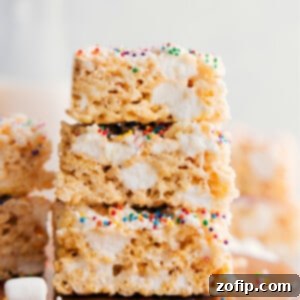 Easy Rice Krispie Treats 3 Rice Krispie Treats squares stacked on top of each other showing the gooey and delicious texture.