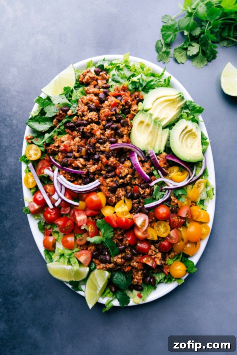 A beautifully composed Ground Turkey Taco Salad with a full array of colorful toppings, including avocado, cheese, tomatoes, and cilantro, served in a bowl, ready to be enjoyed.