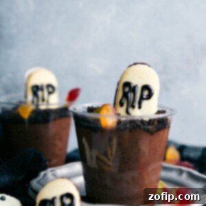 Ghoulish Goodies 3 Individual graveyard pudding cups with cookie crumbs and tombstone shaped cookies.