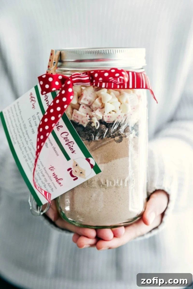 Beautifully layered Mason Jar Peppermint Cookies with a festive ribbon and a free printable recipe tag attached, ready to be gifted.