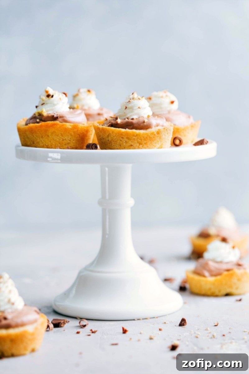A tray of freshly made Sugar Cookie Turtle Pudding Bites, showing the caramel, pudding, whipped cream, and pecans