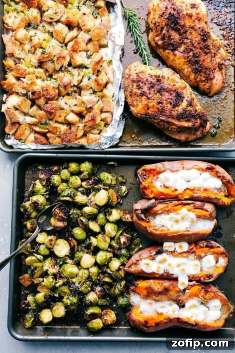 Two baking sheets fresh from the oven, laden with a complete Thanksgiving meal including perfectly roasted turkey, savory stuffing, crispy Brussels sprouts, and tender sweet potatoes, all ready to serve.
