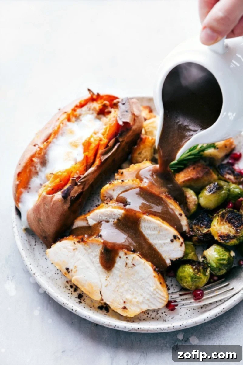 A warm, inviting Thanksgiving dinner plate with turkey, gravy, dressing, sweet potatoes, and Brussels sprouts, ready to be served, all prepared on two convenient sheet pans.