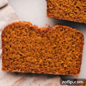 A single slice of the delicious and fluffy pumpkin bread, showcasing its tender interior.
