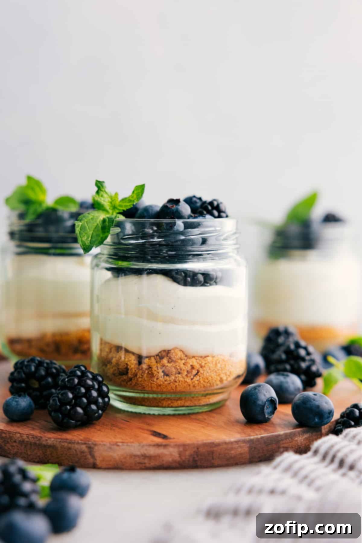 Beautifully layered no-bake cheesecake in a glass jar, topped with fresh berries, ready to be served.