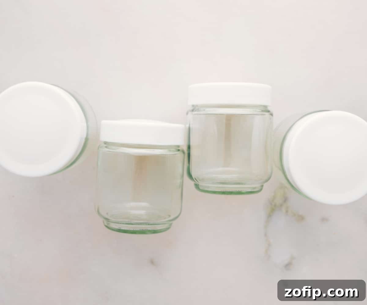 Assortment of fresh ingredients for cheesecake in a jar, including cream cheese, graham crackers, butter, and berries.