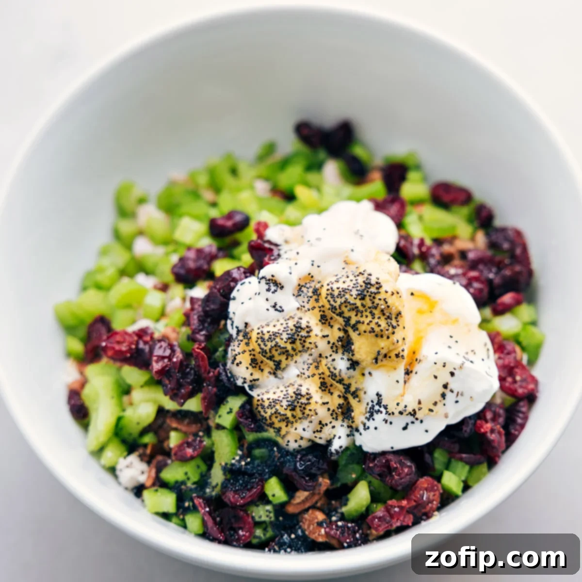 All the chicken salad ingredients beautifully combined in a large bowl, showcasing its creamy texture and colorful mix-ins, ready to be served.