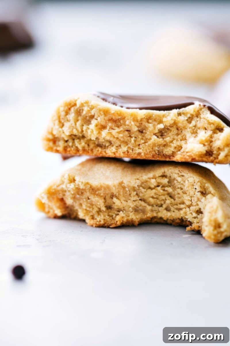 Deliciously thick and soft peanut butter cookies, some dipped in melted chocolate, arranged on a cooling rack.