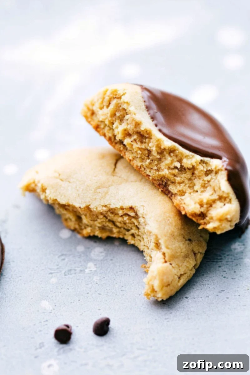 A perfectly baked peanut butter cookie, split in half to reveal its incredibly soft, thick, and chewy interior.