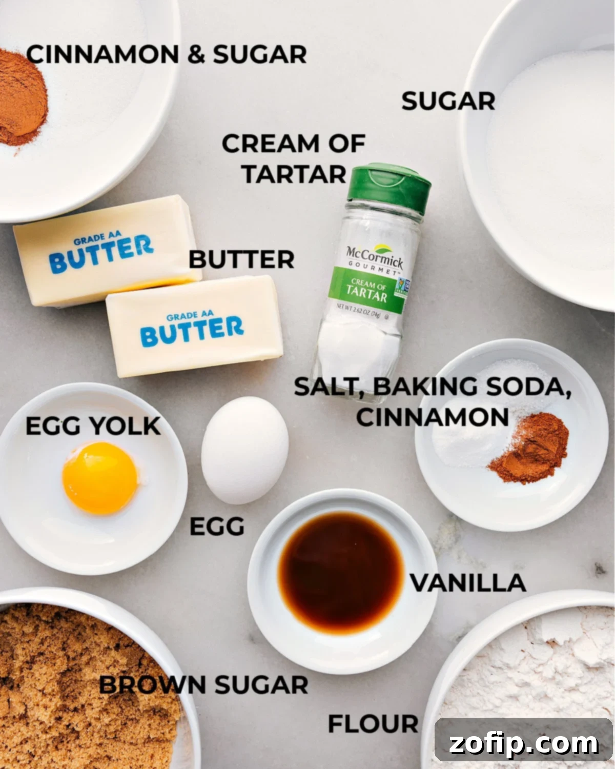Essential Snickerdoodle Cookie Ingredients Various ingredients for making the snickerdoodle recipe arranged on a kitchen counter, including flour, sugar, eggs, and cinnamon.