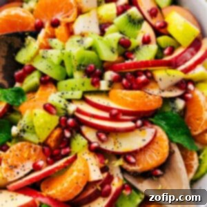 A close-up shot of the vibrant winter fruit salad with poppy seed dressing in a bowl.