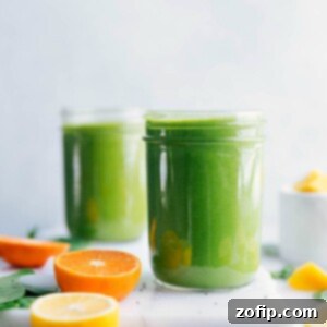Your Green Elixir 2 A vibrant green smoothie in a glass, with fresh fruit and spinach leaves arranged around it.