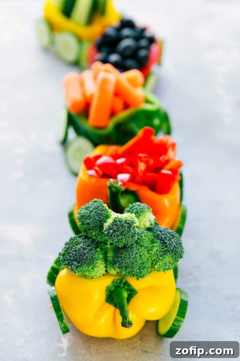 A creative veggie platter designed to look like a festive train, made with colorful vegetables and served with a creamy dip, perfect for Christmas or birthday parties.