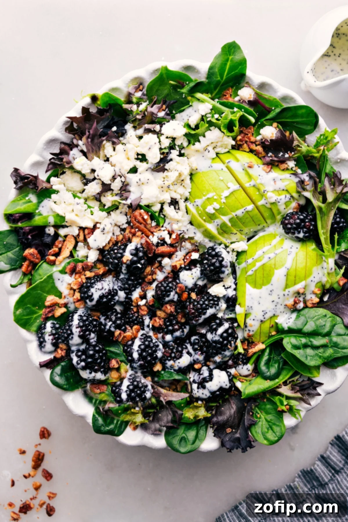 Vibrant Blackberry Salad with creamy poppy seed dressing in a large serving bowl, showcasing fresh berries, pears, and pecans.