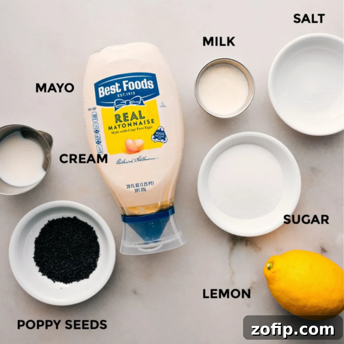 All the creamy poppy seed dressing ingredients neatly laid out, including mayonnaise, milk, heavy cream, sugar, lemon, apple cider vinegar, salt, and poppy seeds, ready for blending.