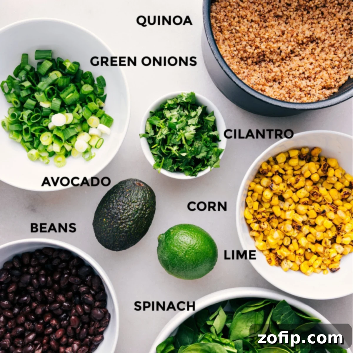 Fresh ingredients for Quinoa Corn Salad, including sliced avocado, golden corn kernels, black beans, vibrant cilantro, and chopped green onions, arranged appealingly.