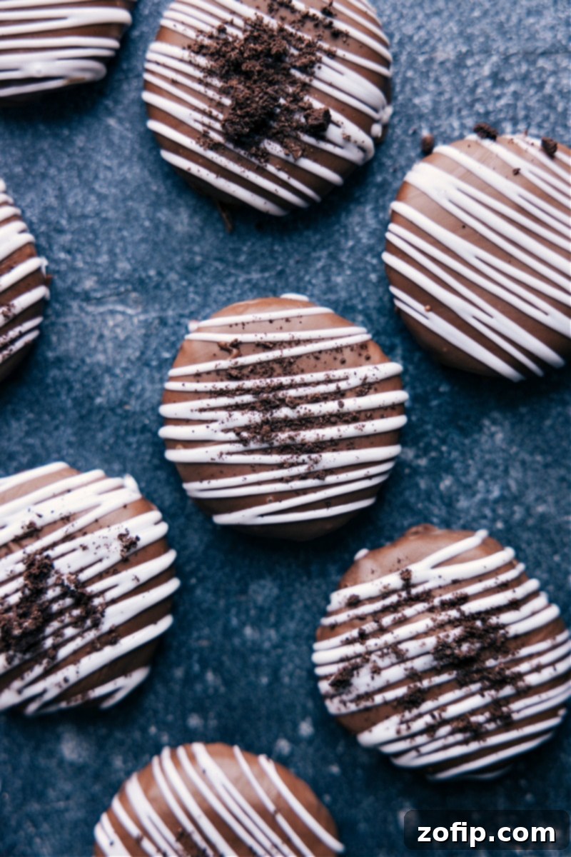 Delicious Oreo Truffles: Super easy, no-bake, and only 5 ingredients! Crush Oreos, mix with cream cheese, dip in chocolate, and add an optional drizzle. A major hit at any event! An overhead shot of finished Oreo Truffles, beautifully arranged and ready to be enjoyed, showcasing a white chocolate drizzle.