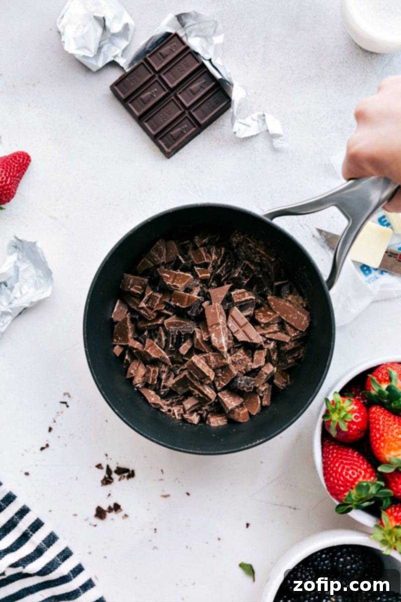 Melting the chocolate and milk in a pot over low heat for an easy chocolate fondue recipe.