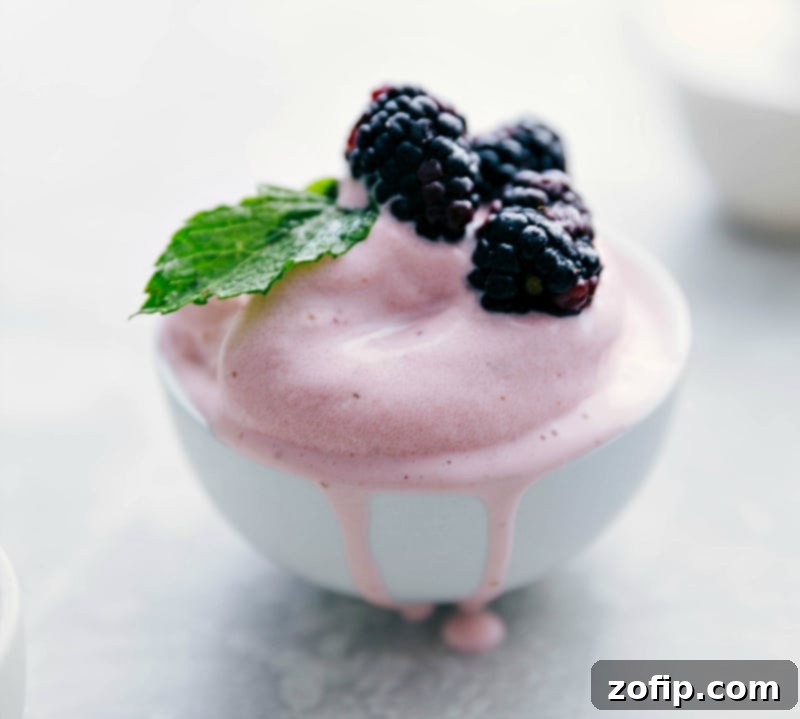A generous bowl of homemade Strawberry Frozen Yogurt, adorned with a colorful array of fresh berries including strawberries, blueberries, and blackberries, ready to be enjoyed.