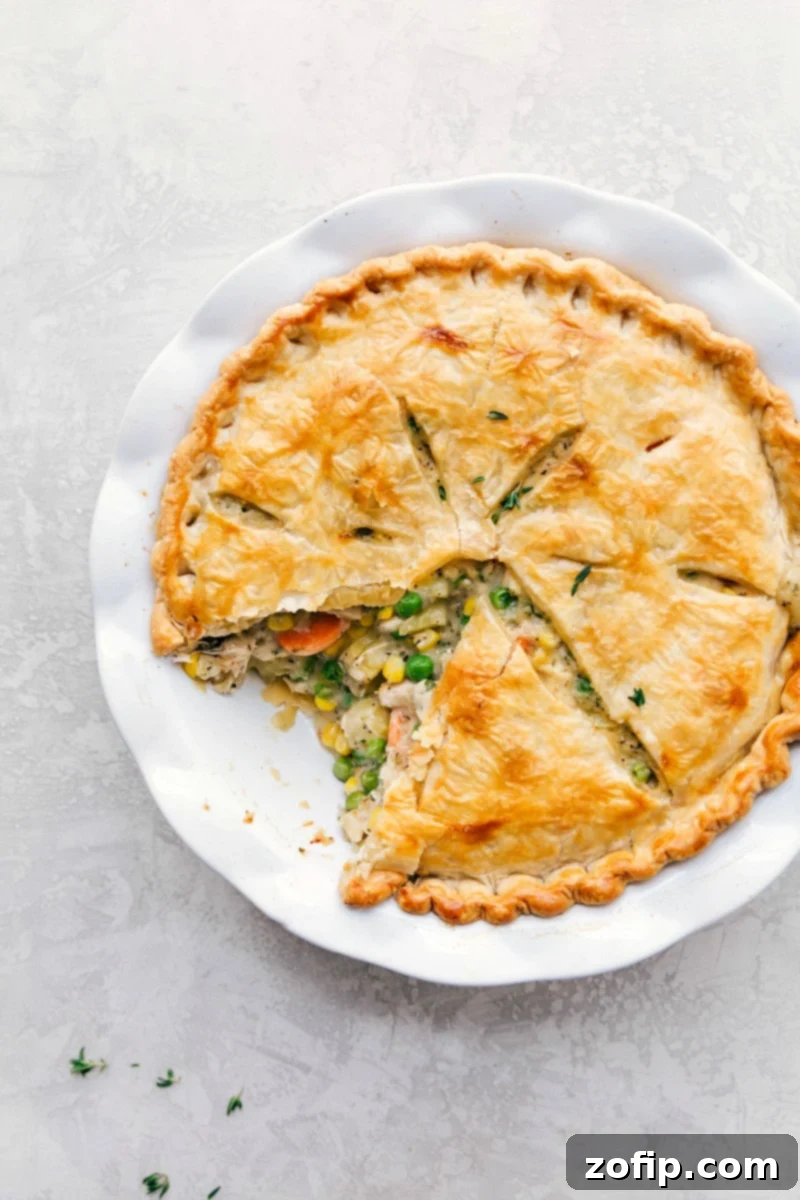 Homemade chicken pot pie recipe with a slice removed, showcasing a beautifully golden crust, ready to be savored.