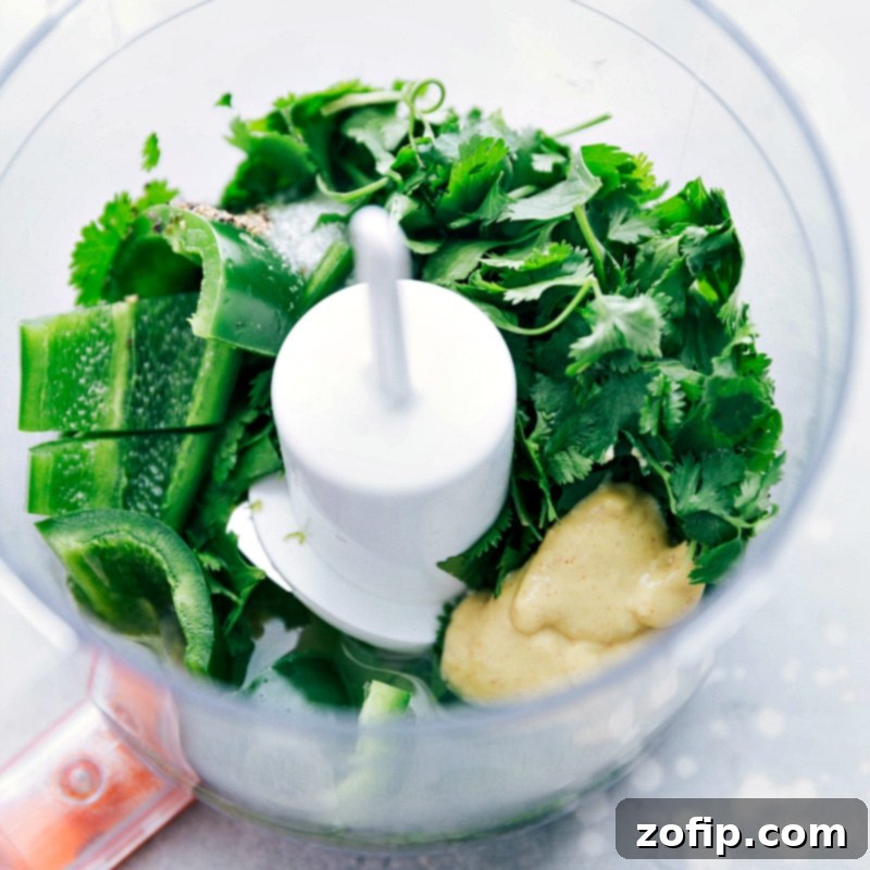 Preparing the fresh cilantro-lime vinaigrette in a mini food processor, showcasing the vibrant green color of the zesty dressing.