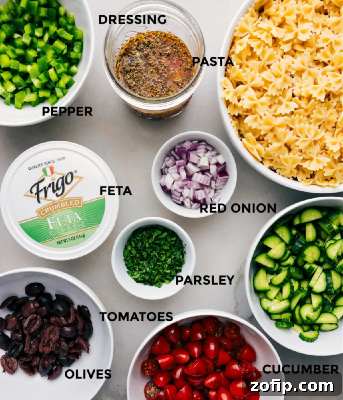 All the fresh ingredients used in this Greek Pasta Salad, prepped and arranged for cooking.