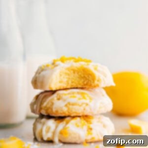Perfectly glazed lemon cookies stacked on a white plate