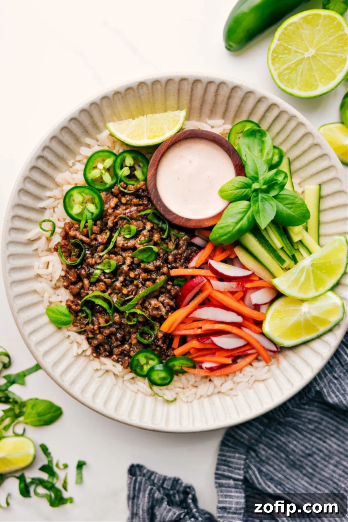 Delicious And Flavorful Banh Mi Bowls with Tender Pork and Crisp Veggies Banh Mi Bowls on a bed of rice, served with a side of cucumber, pickled carrot, and radish salad, along with a tasty Sriracha-lime sauce.