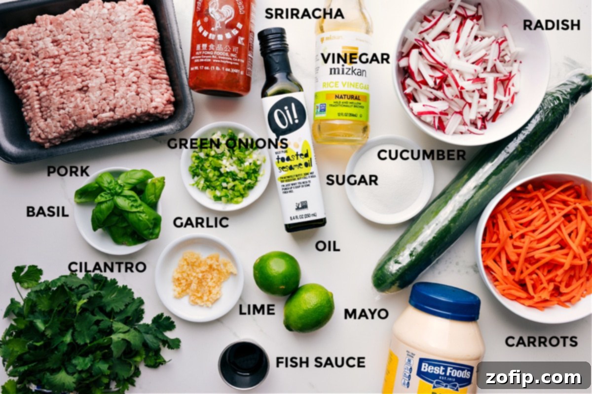 Key Ingredients for Flavorful Banh Mi Bowls All the fresh ingredients for homemade Banh Mi Bowls, including ground pork, Sriracha, rice vinegar, sesame oil, green onions, fresh basil, cilantro, garlic, lime, mayonnaise, fish sauce, carrots, cucumber, sugar, and radishes.