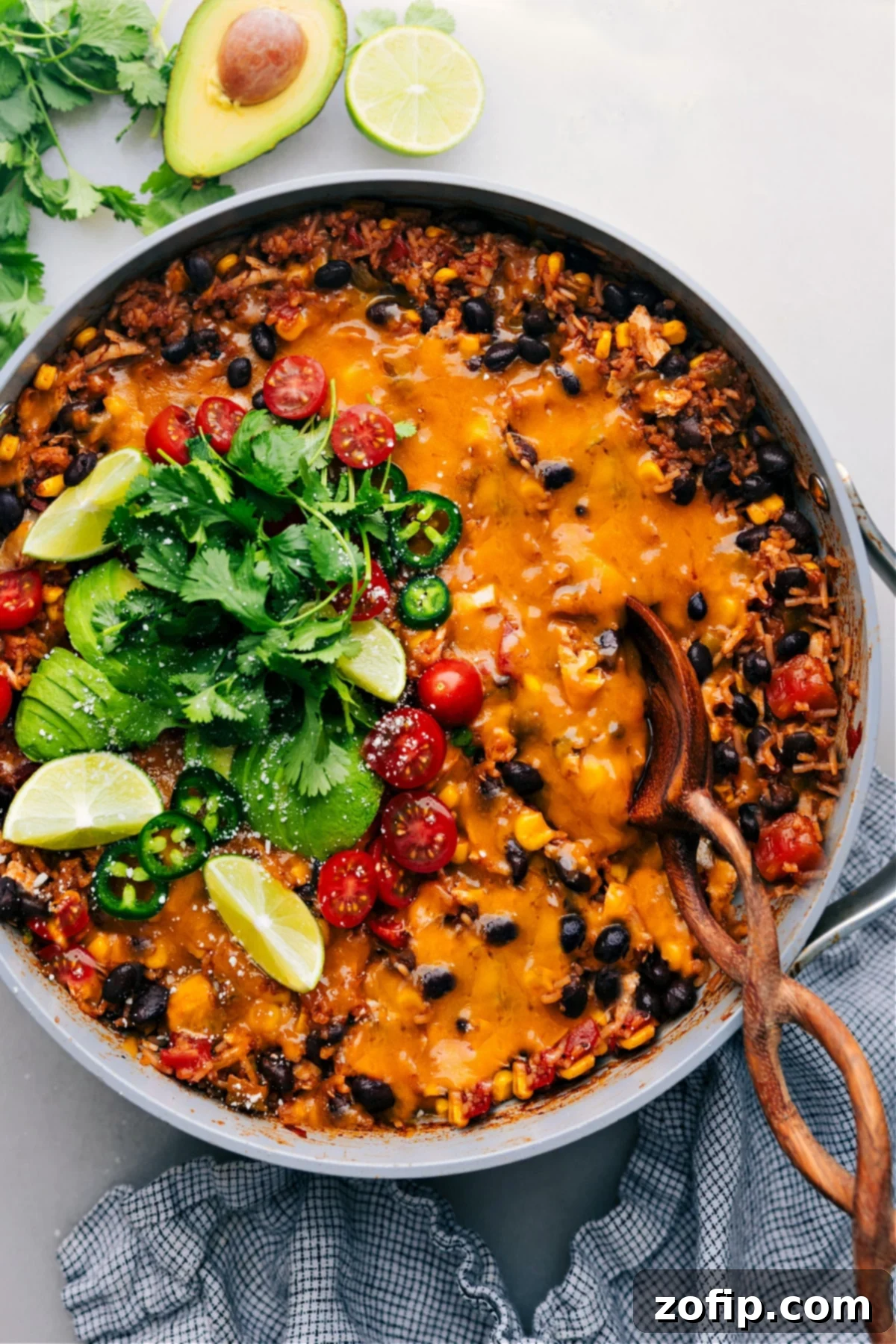 A vibrant One-Pot Burrito Bowl dish served in a rustic skillet, showcasing cheesy chicken, seasoned rice, black beans, and corn, ready to be enjoyed.