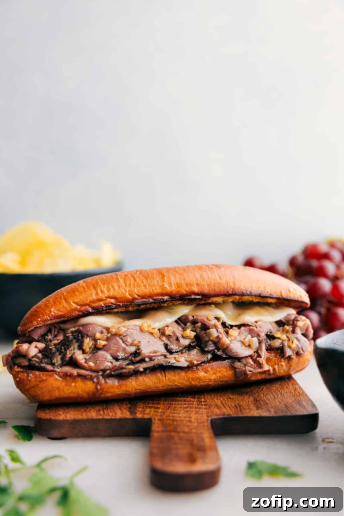 Easy and melty French Dip Sandwiches ready to be enjoyed, showcasing the golden-brown buns, tender beef, and melted cheese with a side of au jus.