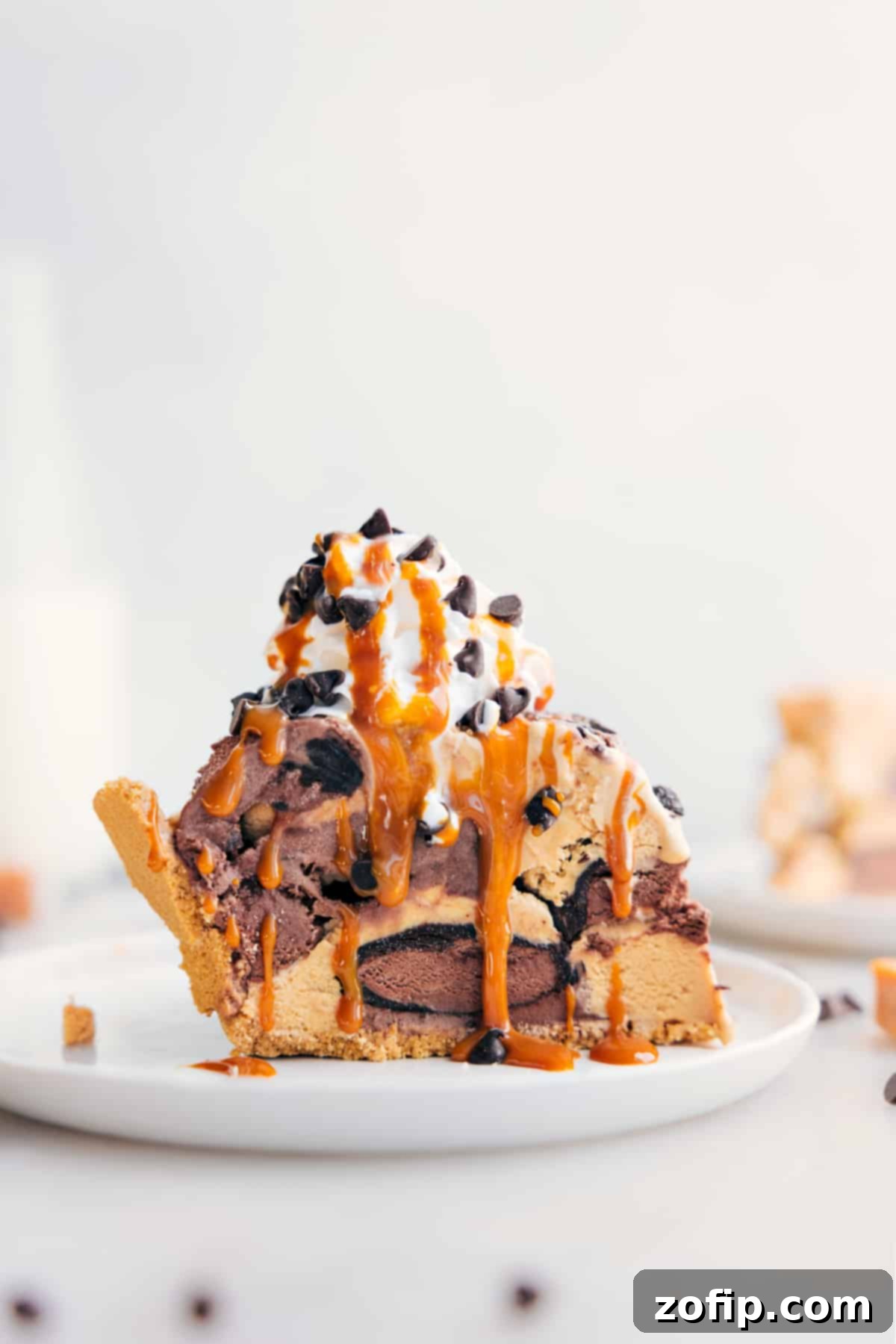 The Best Ice Cream Pie Recipe That Takes Minutes To Prepare Slice of Ice Cream Pie with whipped cream, drizzle of caramel, and chocolate chips on top.