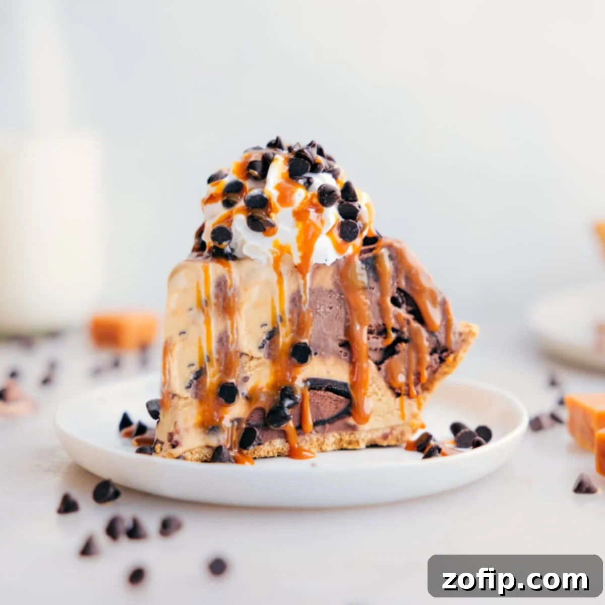 Decadent And Delicious Ice Cream Pie Recipe A slice of the ice cream pie dessert recipe on a plate showing the layers of different ice cream and toppings.