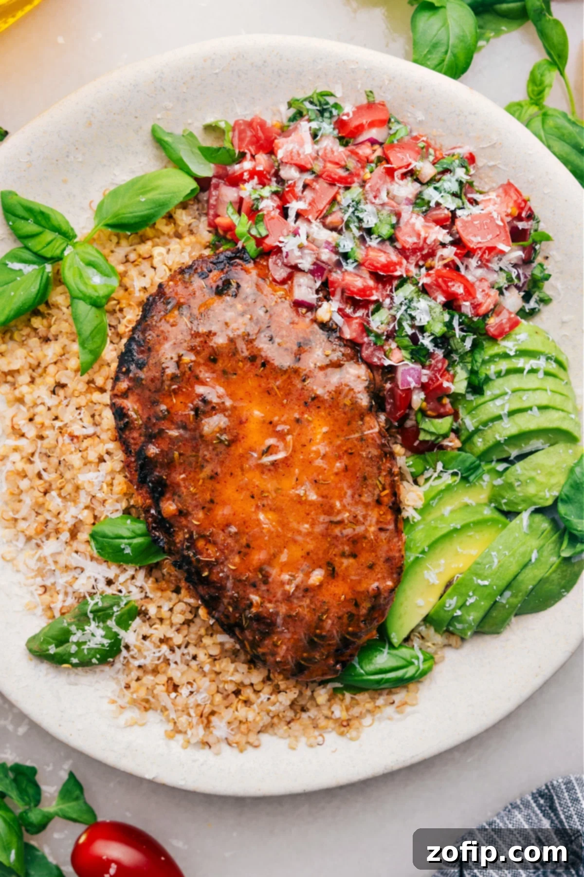 The Ultimate Bruschetta Chicken Recipe Bruschetta Chicken on a bed of quinoa with fresh bruschetta and avocado on the side.