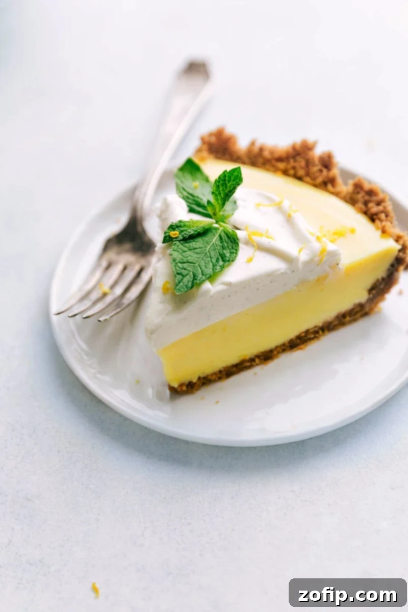 A perfectly sliced Lemon Pie, revealing its creamy layers and golden crust, served on a plate with fresh mint garnish.