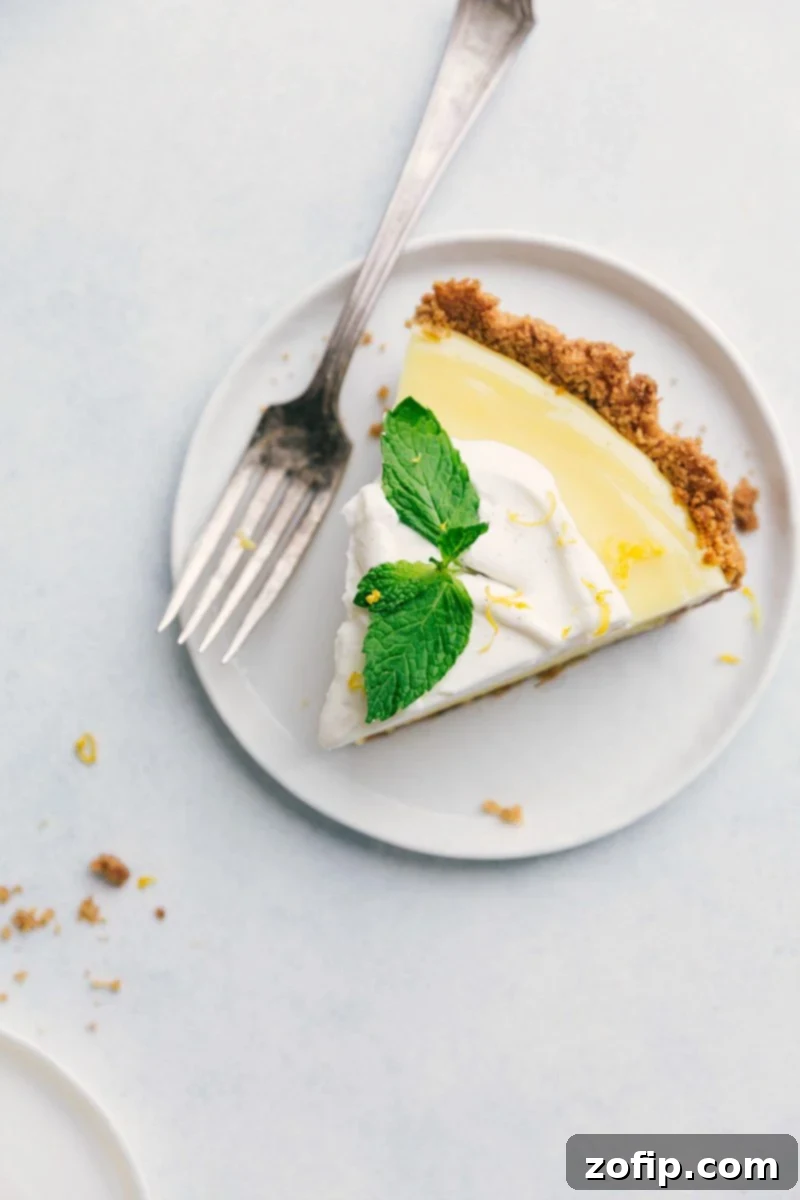 A beautiful slice of homemade Lemon Pie, garnished with fresh mint, ready to be enjoyed.