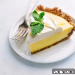 Slice of Lemon Pie on a plate with fresh mint on top.