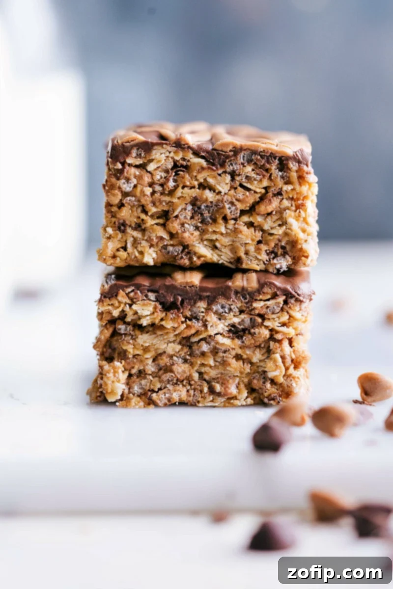 Two homemade no-bake chocolate peanut butter cereal bars stacked, ready to be enjoyed.