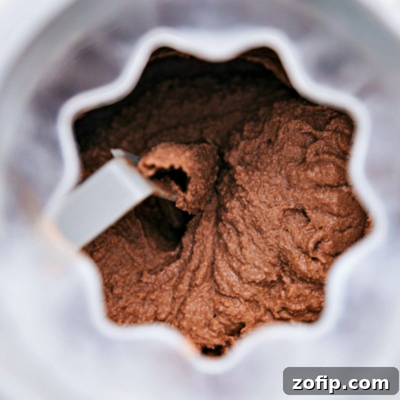 Churning Chocolate Gelato in Ice Cream Maker Chocolate gelato churning smoothly in an ice cream maker, illustrating the process of achieving a perfect creamy texture.