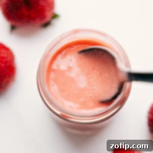 A beautifully presented bowl of fresh berry salad, generously drizzled with homemade Strawberry Balsamic Vinaigrette, ready to be enjoyed.