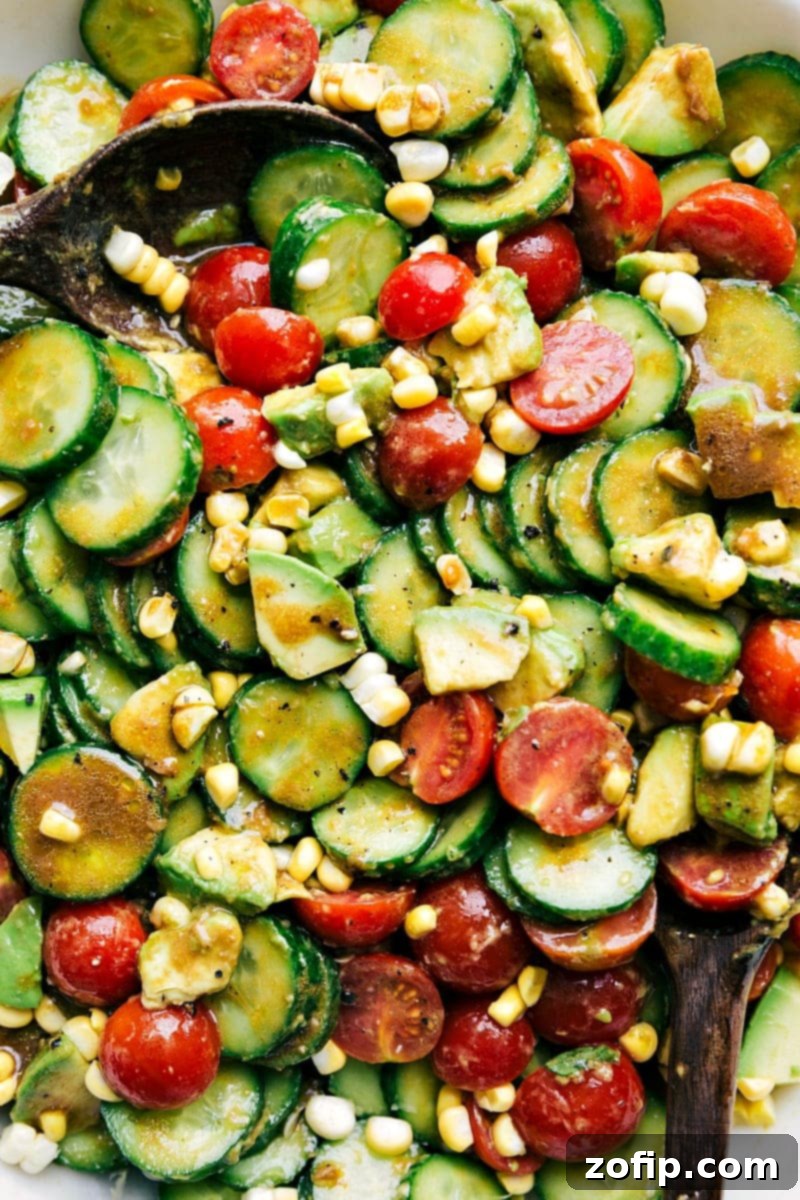 The best cucumber salad recipe! This beauty adds tomatoes, corn and avocado, with a balsamic vinaigrette. Recipe via ChelseasMessyApron.com #cucumbers #cucumbersalad #vegetarian #refreshing #corn #balsamic Closeup of the refreshing Cucumber Salad with corn, avocado, and tomatoes