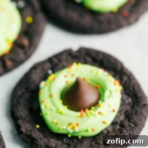 Finished Witch Hat Cookies with a chocolate cookie base, green frosting, and chocolate kisses on top.