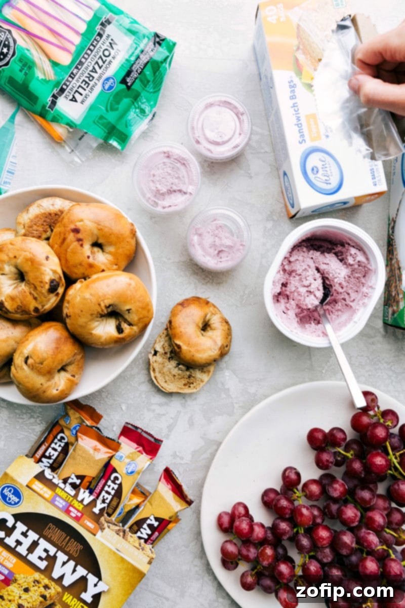 Healthy School Lunch Components A healthy school lunch, including bagels, string cheese, cream cheese, grapes, and granola bars, arranged for easy packing.