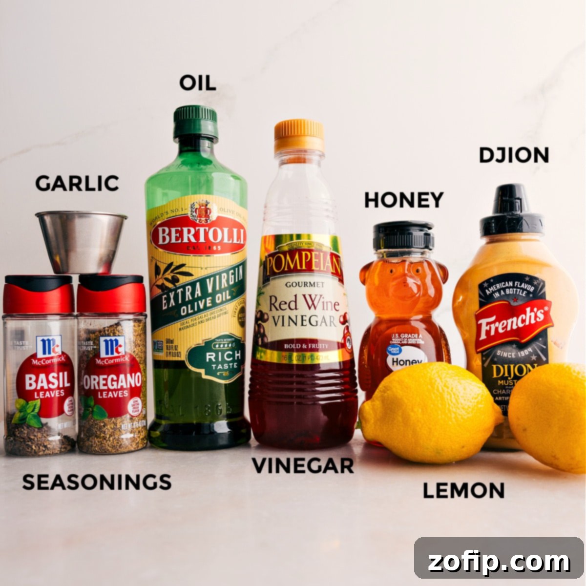 All the fresh ingredients for the homemade lemon dressing, including vibrant seasonings, olive oil, mustard, honey, fresh lemons, and minced garlic, neatly prepped for easy assembly.